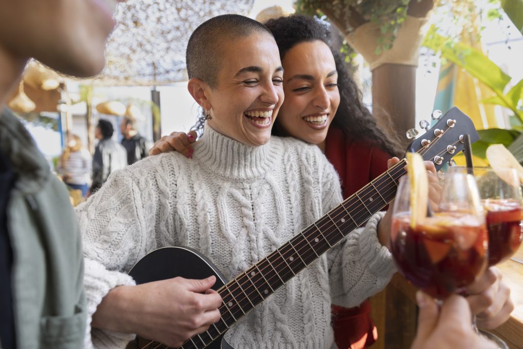 Una mujer tocando y cantando letras de canciones populares antiguas españolas en grupo con sus amigos.