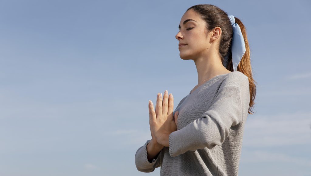 Una mujer meditando, aprendiendo una lección de uno de sus libros de autoayuda.