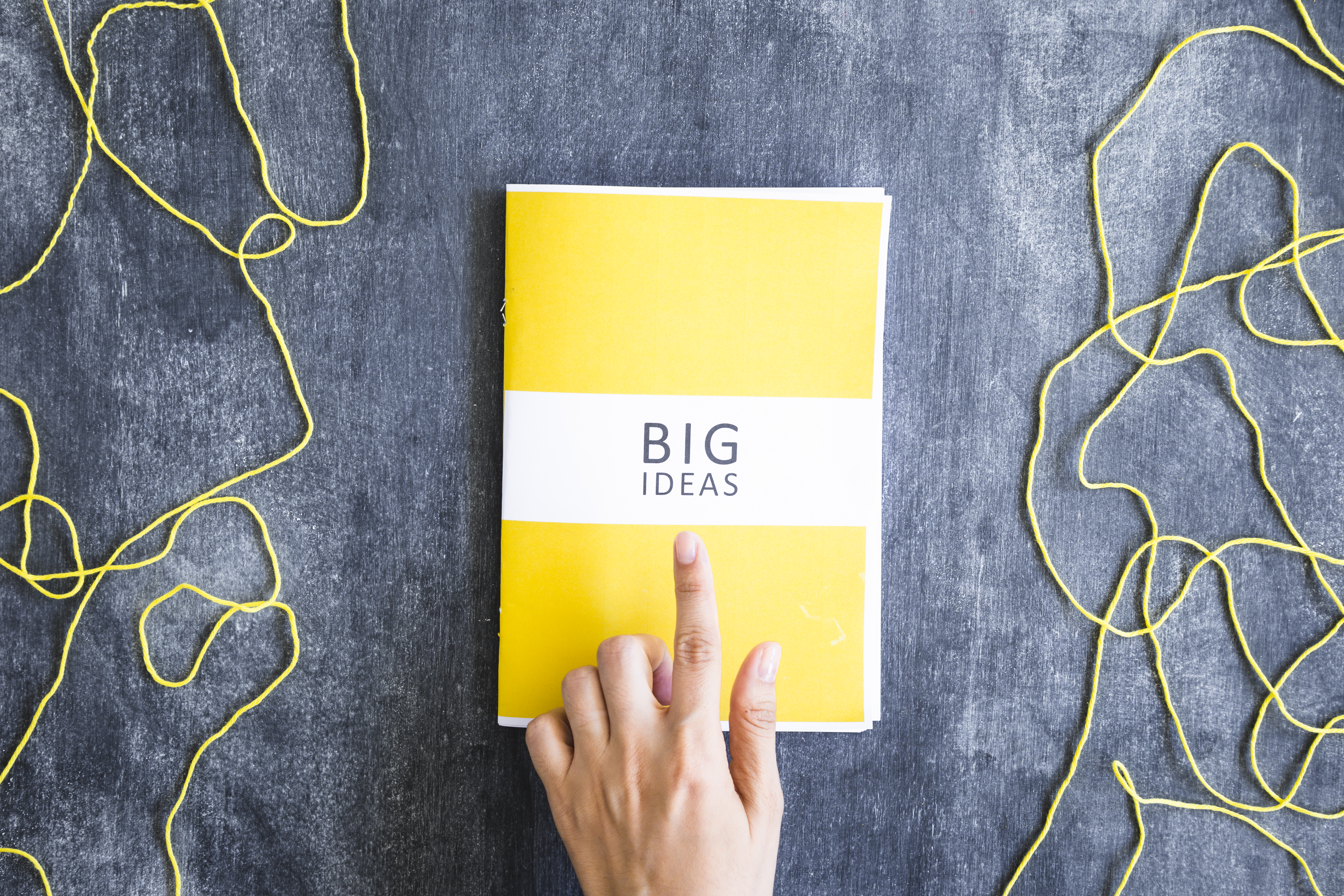 Una persona señalando con el dedo a un libro amarillo de crecimiento personal y espiritual, siendo este de los mejores.